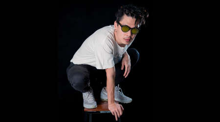Close-up of young asian  man sit on dark  background, lovely model .