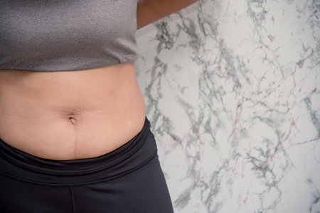 woman touching his belly on white background , fatの写真素材