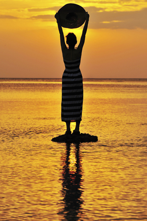 Women in Black Shadow Sea before sunsetの写真素材