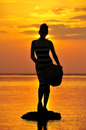 Women in Black Shadow Sea before sunsetの写真素材
