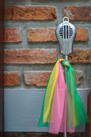 Old microphone with multicolored tieの写真素材
