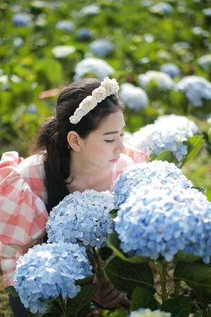 Beautiful woman in a hydrangea flower garden.の写真素材