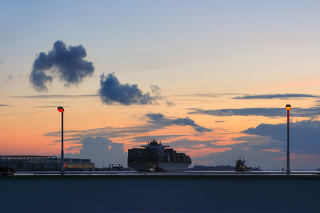 Hamburg, Germany - August 8, 2012: shipping on the Elba river in twilight. Cargo ship and industrial premises of the Airbus plant in Hamburg Finkenwerder.のeditorial素材
