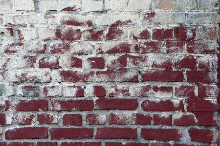 Dirty brick wall. The shabby brick wall stained with white paint.の写真素材