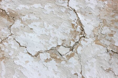 The texture of an aged stucco with cracks.