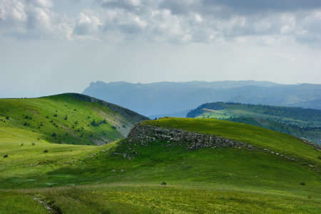 Picturesque mountain landscape on a sunny day with clouds. In the background is the famous mountain...