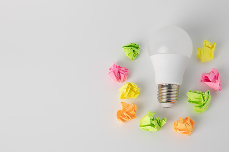 multi-colored sticky notes crumpled papers ball Light bulb on white background office concept no ideaの写真素材