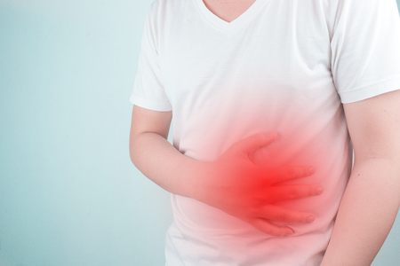 Asian Young men are suffering from stomach ulcers. gastritis Caused by the infection of H. pylori bacteria  healthcare and health problem conceptの写真素材