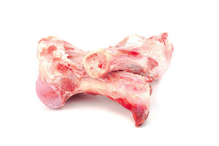 Close up frozen fresh pork bones with red meat stuck To be used for making pork bone broth on a white backgroundの写真素材