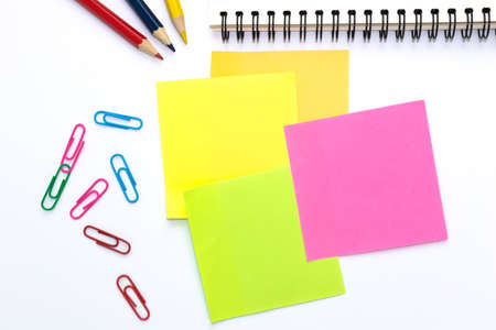 color pencils and notebooks, sticky note, paper clip in many colors and placed on a white background...