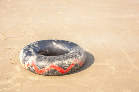 black lifebuoy on the sand on the beachの写真素材