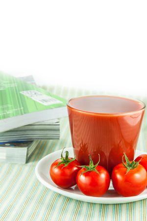 Tomato juice in glass and fresh tomatoes on tableの写真素材