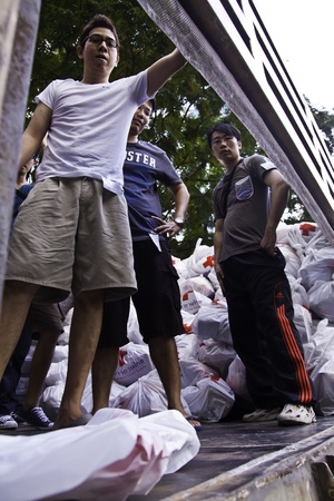 During the flood crisis, Thai peoples and foreigners in Bangkok still devote themselves to help Red-Cross foundation to prepare the disaster relief packages and send to the flood victims in the risky areas.のeditorial素材