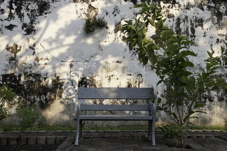 The old bench is at the grungy wall on the side of the street. It makes us feel so serene when...