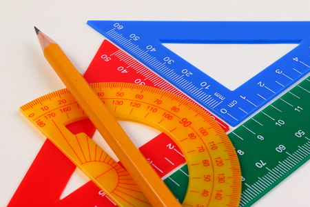 Drawing angles with set squares, pen, notebook and paper on plywood drawing board.の写真素材