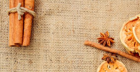 Cooking spice concept, cardamom, cinnamon, puff pastry, wooden spoon and dried quince With brown linenの写真素材