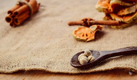 Cooking spice concept, cardamom, cinnamon, puff pastry, wooden spoon and dried quince With brown...