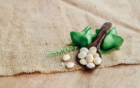 sacha peanut concept, Inca nut  fresh and green with wooden spoon on brown linen