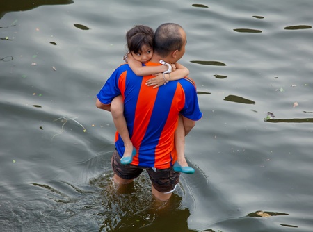 BANGKOK, THAILAND - NOVEMBER 5, 2011 : An unidentified man rescues girl during the worst flooding in decades on November 5,2011 Bangkok, Thailand.のeditorial素材