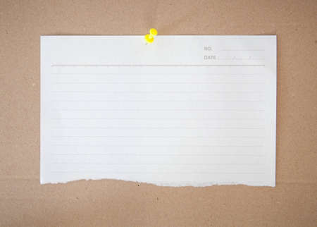 paper sheet and pin on wood texture backgroundの写真素材