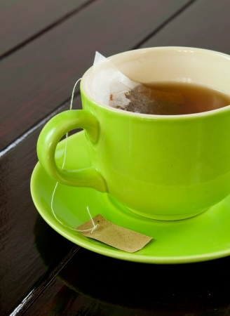 green cup of hot tea on wood backgroundの写真素材