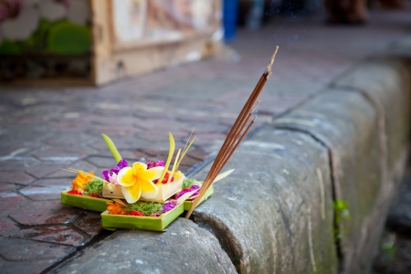 Traditional balinese offerings to gods in Bali with flowers and aromatic sticksの写真素材