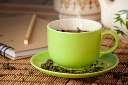 green cup of hot tea on wood backgroundの写真素材