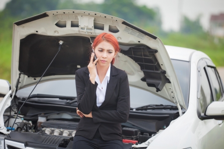 Young beautiful business asian woman with car broke downの写真素材