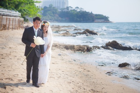 Happy young asian couple in love outdoor on the beachの写真素材