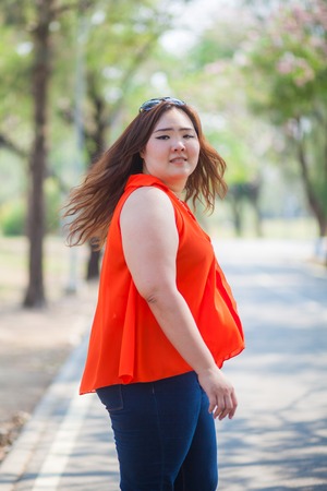Happy fatty asian woman posing outdoor in a parkの写真素材