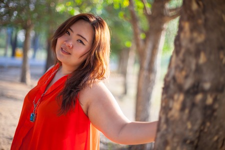 Happy fatty asian woman posing outdoor in a parkの写真素材
