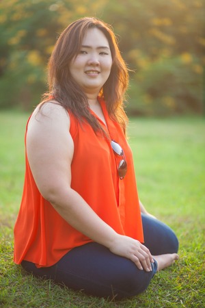 Happy fatty asian woman posing outdoor in a parkの写真素材