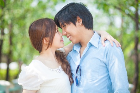 Loving asian couple under tree in the parkの写真素材