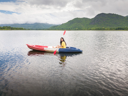 Woman kayaking on lake and mountain in Thailandの写真素材