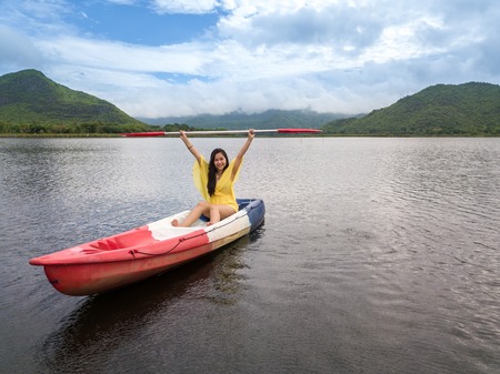 Woman kayaking on lake and mountain in Thailandの写真素材