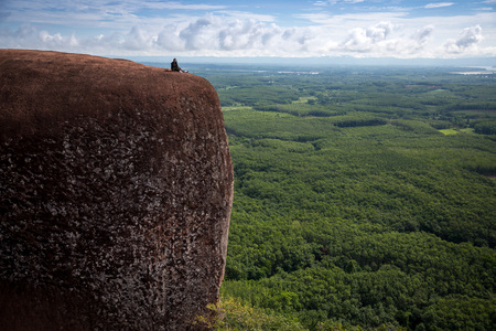 Young woman sitting on a mountain top at Phu Sing, Hin Sam Wan, Buengkan, Thailand