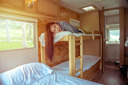 Beautiful young asian woman in a camper van on a summer day