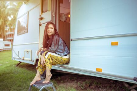 Beautiful young asian woman in a camper van on a summer dayの写真素材