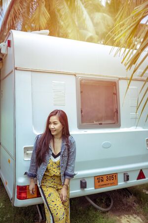 Beautiful young asian woman in a camper van on a summer day