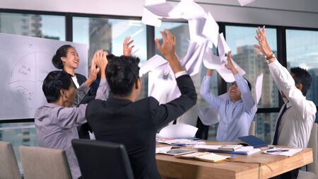 Asian business team throwing paper when meeting successの写真素材