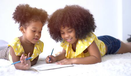 Portrait of cute little African student doing schoolwork