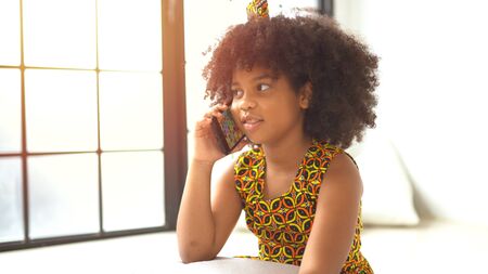 Cute african american girl talking on a mobile phone.の写真素材
