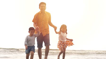 Happiness Father and son and daughter playing on the beachの写真素材