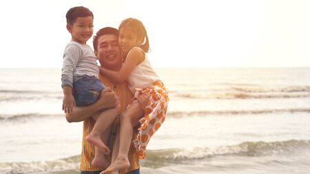 Happiness Father and son and daughter playing on the beachの写真素材