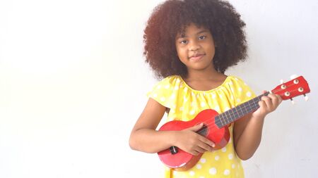 Portrait of happy little smile african girl with guitarの写真素材