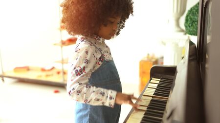 beautiful little african kids are playing on piano musicの写真素材