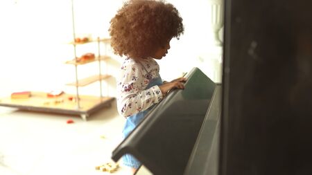 beautiful little african kids are playing on piano musicの写真素材