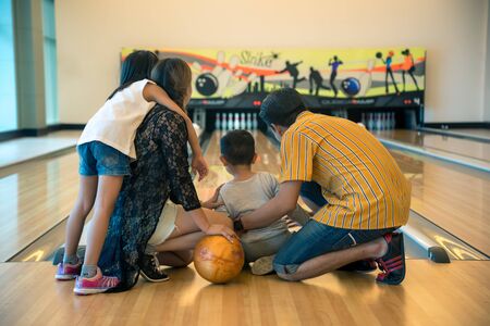 Young family having fun bowling at bowling clubの写真素材
