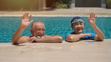 Senior Couple Relaxing In Swimming Pool Together