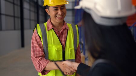 warehouse workers shaking hand in distribution warehouse.の写真素材